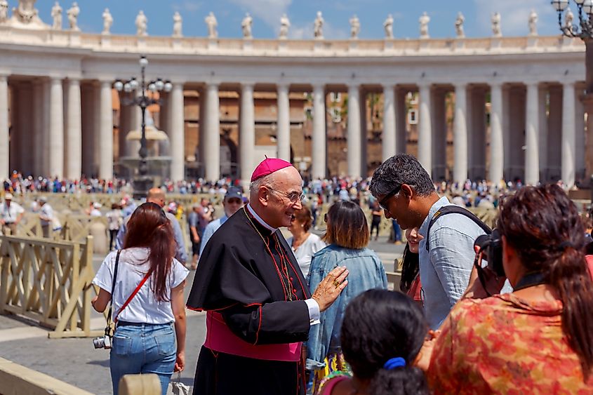 ishop and tourists at St. Peter's Square in Vatican. St. Peter's Square is most visited place in Rome. Editorial credit: kavalenkau / Shutterstock.com